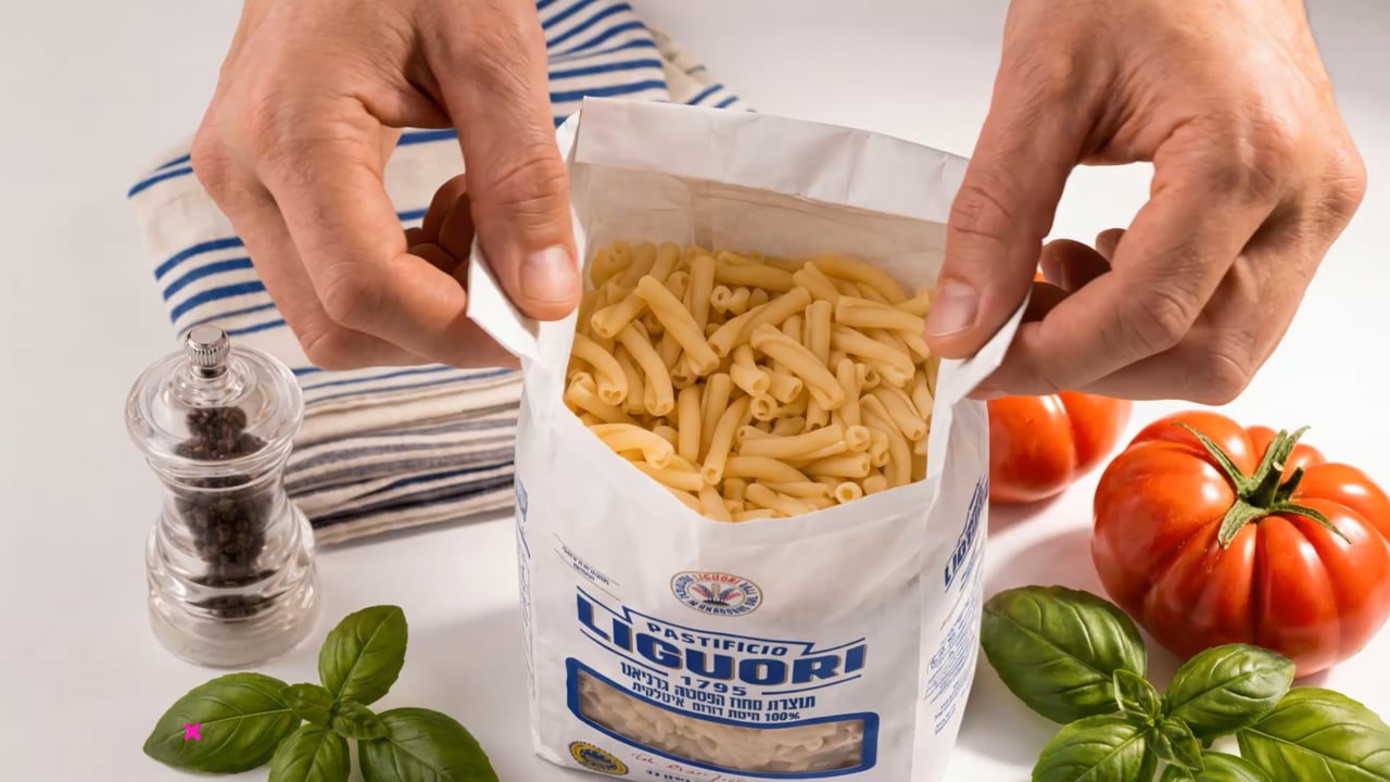 Liguori pasta with tomatoes and basil on a light kitchen worktop